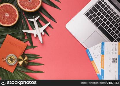 composition small plane passport compass laptop tickets grapefruit plants leaves