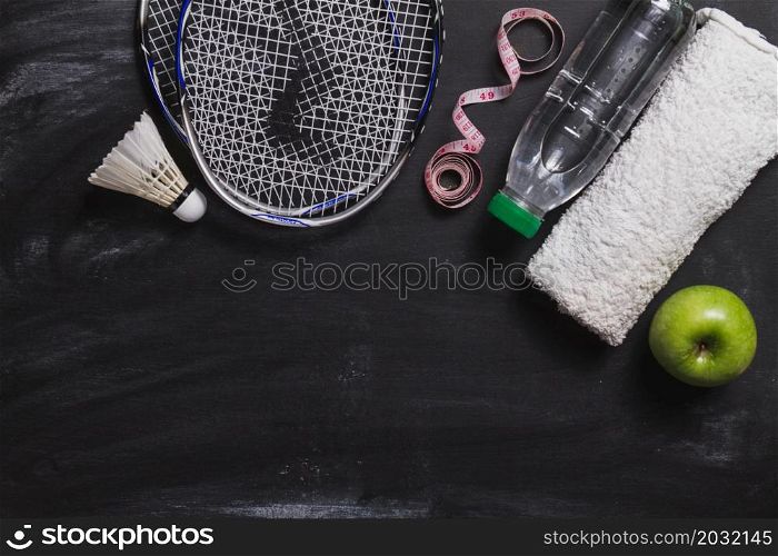 composition with badminton racket water bottle apple