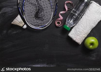 composition with badminton racket water bottle apple