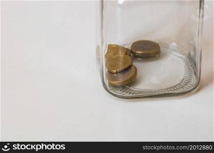Composition with saving money coins in a glass jar. Concept of investing and keeping money, close up isolated.