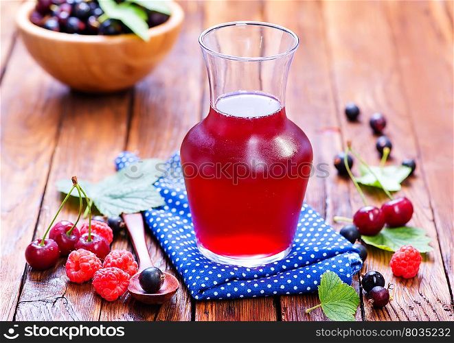 compot from berries in jug and on a table