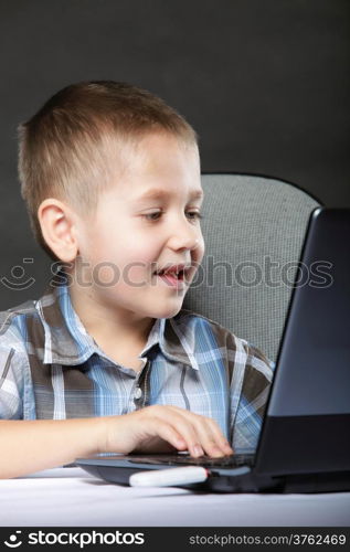 Computer addiction child boy with laptop notebook black background