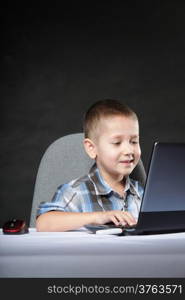 Computer addiction child boy with laptop notebook black background