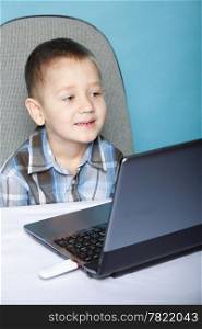 Computer addiction child boy with laptop notebook blue background