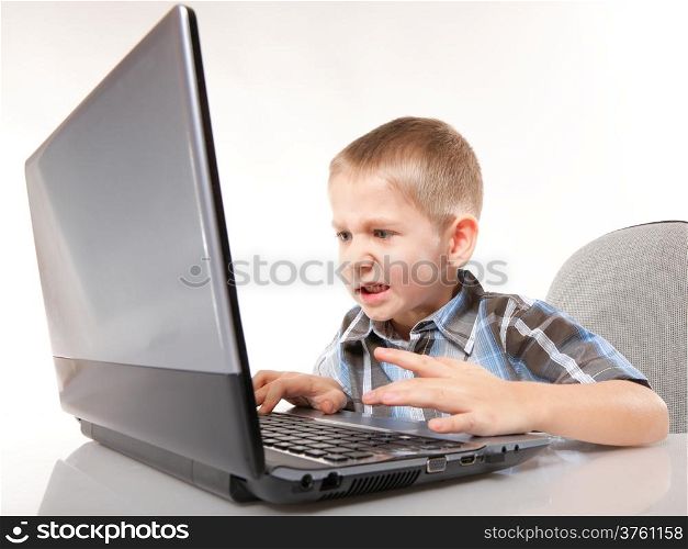Computer addiction emotional child boy with laptop notebook playing games isolated on white background
