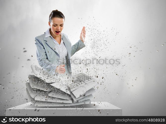 Computer addiction. Image of businesswoman crushing with hand pile of keyboards