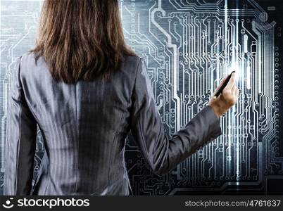 Computer concept. Rear view of businesswoman drawing curcuit board