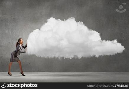 Computer connection. Attractive businesswoman pushing big cloud with effort