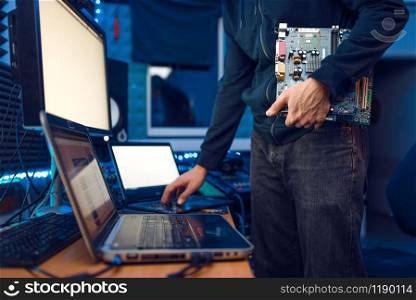 Computer engineer holds PC motherboard, network equipment maintenance. IT-manager at his workplace, professional business security