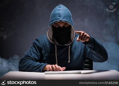 Computer hacker working in dark room