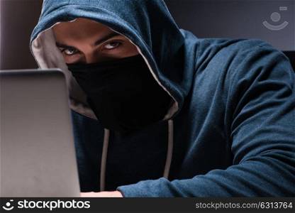 Computer hacker working in dark room