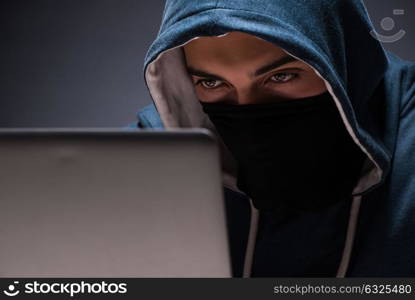 Computer hacker working in dark room