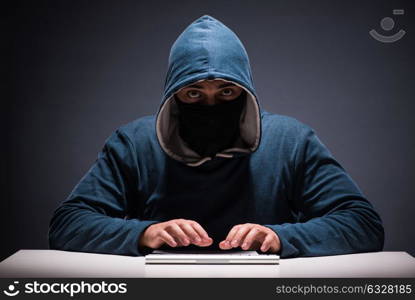 Computer hacker working in dark room