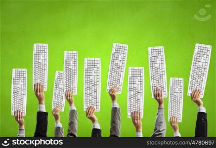 Computer keyboard. Group of business people holding keyboards in raised hands