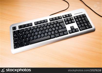 Computer keyboard on the wooden polished table