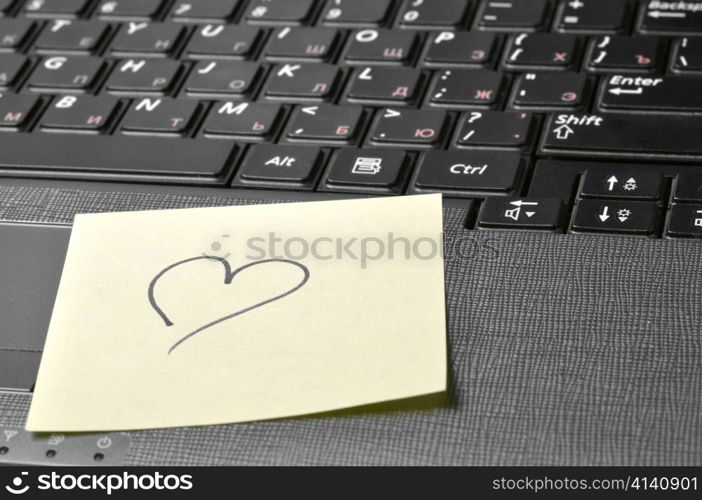 computer keyboard with heart on sticky note