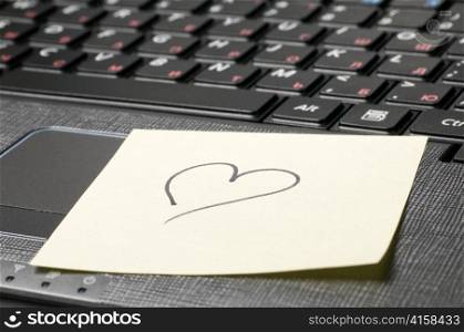 computer keyboard with heart on sticky note
