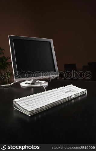 Computer monitor and keyboard on desktop.