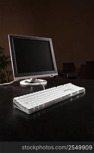 Computer monitor and keyboard on desktop.