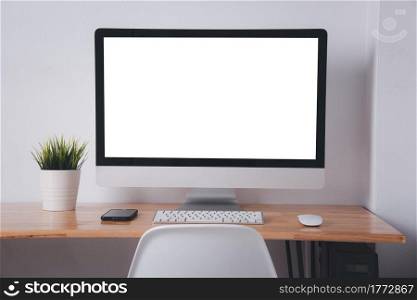 Computer monitor with white blank screen on the business desk with wireless mouse, keyboard at home office over white wall background, Photo of equipment contemporary workspace