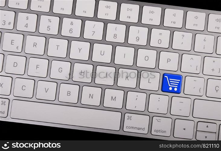Computer notebook keyboard with icon shopping cart on key. E-commerce concept