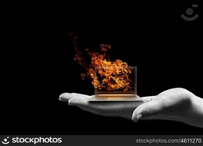 Computer problems. Human hand holding burning laptop on palm