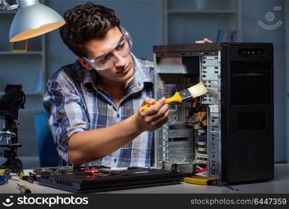 Computer repair man cleaning dust with brush