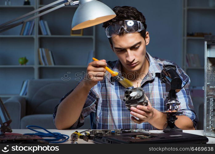 Computer repair man cleaning dust with brush