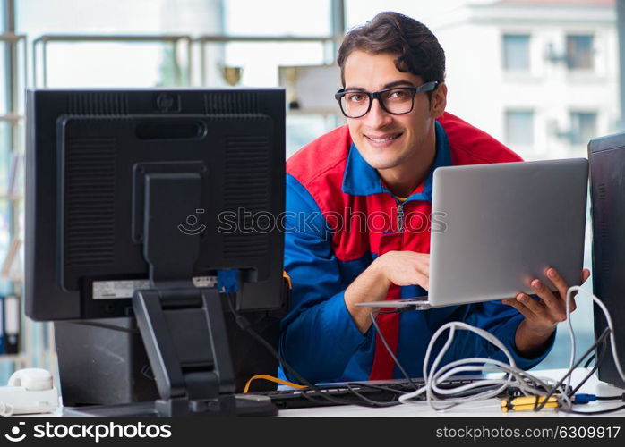 Computer repairman working on repairing computer in IT workshop