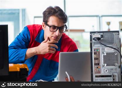 Computer repairman working on repairing computer in IT workshop. The computer repairman working on repairing computer in it workshop