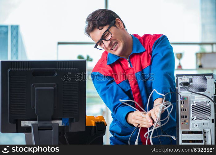 Computer repairman working on repairing computer in IT workshop. The computer repairman working on repairing computer in it workshop