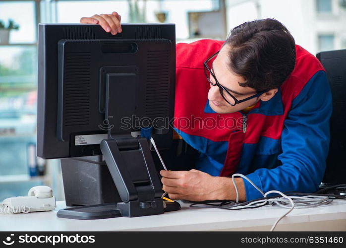 Computer repairman working on repairing computer in IT workshop. The computer repairman working on repairing computer in it workshop