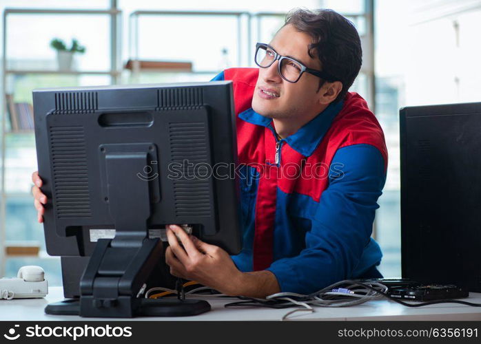 Computer repairman working on repairing computer in IT workshop