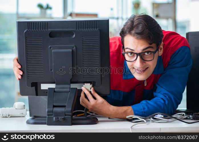 Computer repairman working on repairing computer in IT workshop