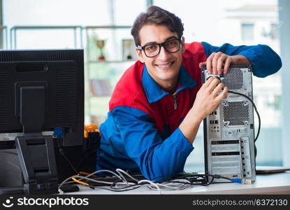 Computer repairman working on repairing computer in IT workshop