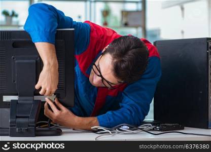 Computer repairman working on repairing computer in IT workshop