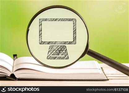 Computer search with a pencil drawing of a personal computer in a magnifying glass
