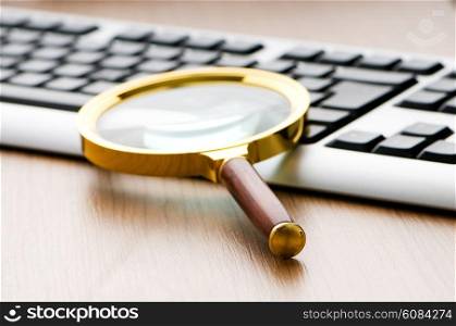 Computer security concept with keyboard and magnifying glass