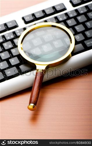 Computer security concept with keyboard and magnifying glass