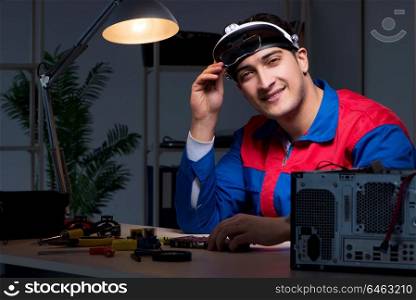 Computer specialist repairing PC late at night
