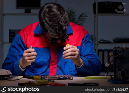 Computer specialist repairing PC late at night