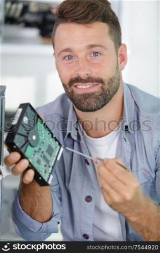 computer technician holding hard drive
