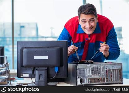 Computer technician repairing broken computer in workshop