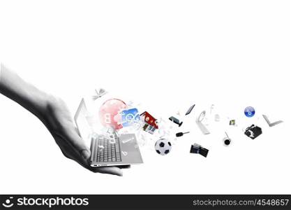 Computer technologies. Close up of hand with laptop and media icons