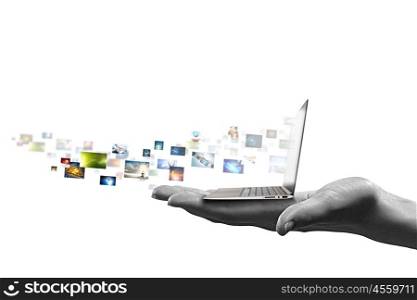 Computer technologies. Close up of hand with laptop and media icons