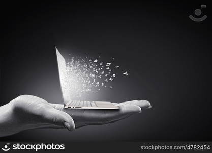 Computer technologies. Close up of hand with laptop and media icons