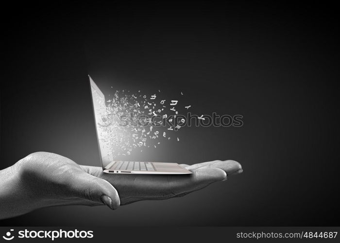 Computer technologies. Close up of hand with laptop and media icons