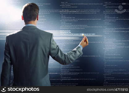 Computing concept. Rear view of businessman touching digital screen