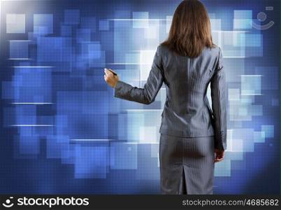 Computing concept. Rear view of businesswoman drawing on media screen