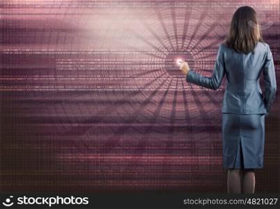 Computing concept. Rear view of businesswoman touching icon of digital screen